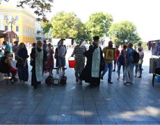 Un prêtre orthodoxe répand de l’eau bénite après une Gay Pride