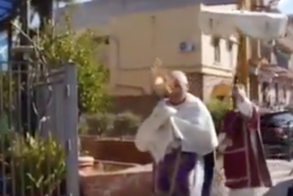 Dans Palerme déserte, un prêtre en procession avec le Saint-Sacrement