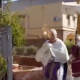 Dans Palerme déserte, un prêtre en procession avec le Saint-Sacrement